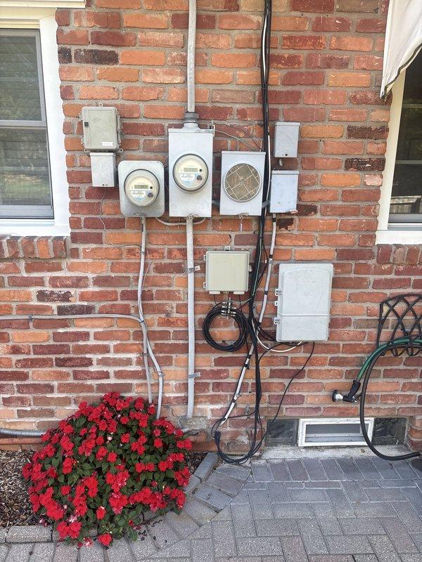 Completed installation of 18kW Generac generator system in right side yard, including all electrical connections, gas piping, and mechanical integration. Installed exterior electrical panel with circuit breakers, metering equipment, and associated junction boxes mounted on brick exterior wall with proper conduit runs. Permit requested for final inspection and all punch list items completed per specifications.