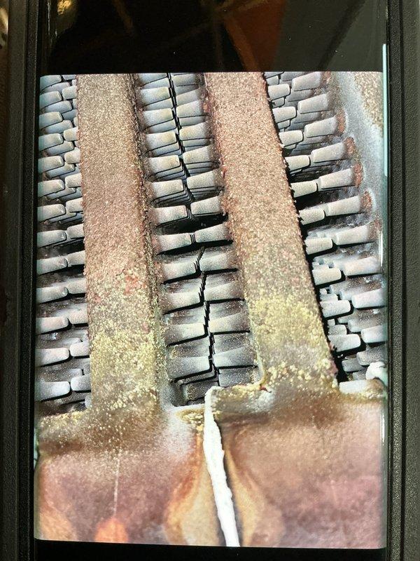 Responded to a service call for a hot water boiler located in the basement to investigate a potential valve issue and perform a tune-up. Upon inspection, observed significant corrosion and oxidation on the copper piping with greenish-blue patina and mineral deposits present, along with visible deterioration on heat exchanger components indicating extended service life and moisture exposure. Evaluated the expansion tank, venting system, gas line configuration, and associated plumbing connections to assess overall system condition and identify any immediate concerns requiring attention.
