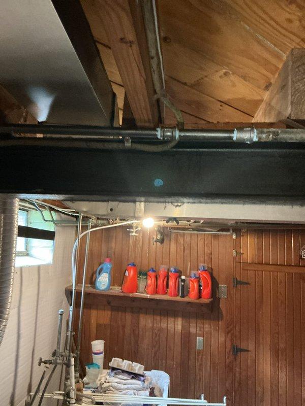 Completed gas line installation for dryer and rebuilt chimney stack in basement utility area. Installed new black steel gas piping with proper mounting brackets and flexible brass connector, ensuring secure connection and code-compliant installation. Performed structural work on stack system, including access port modifications and proper sealing of penetrations through wall surfaces.