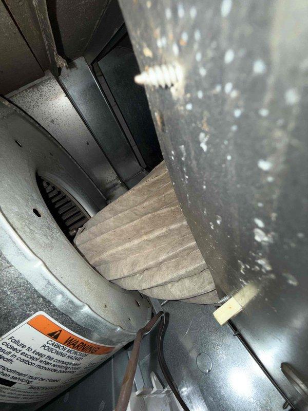 Responded to no heat call on 15-year-old furnace located in basement with reported rattling noise. Upon inspection, found severely clogged air filter with extensive dirt and debris accumulation restricting airflow and causing system malfunction. Replaced heavily soiled filter with new unit, restoring proper airflow and eliminating rattling noise. System tested and confirmed operational with heat output restored to normal levels.