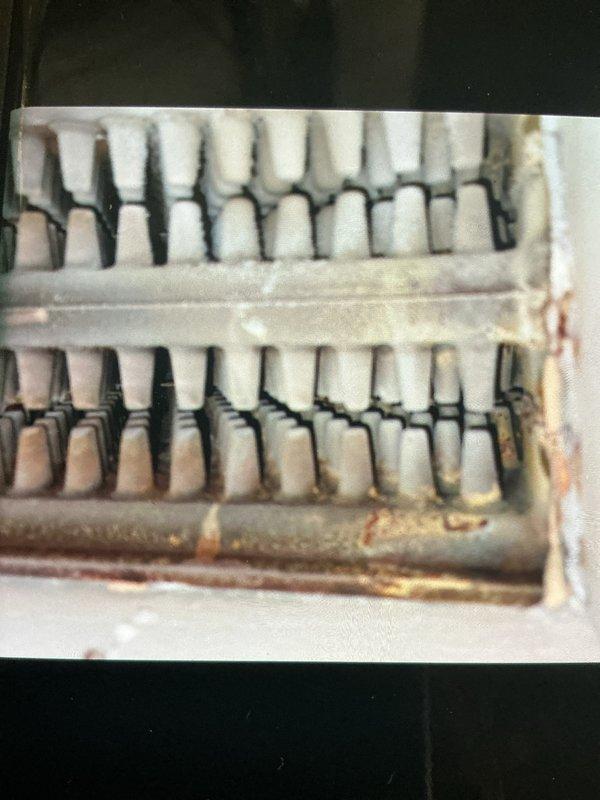 Completed comprehensive Gold Boiler Inspection on 21-year-old steam boiler system located in basement. Performed thorough visual examination of heat exchanger components, identifying moderate rust staining and corrosion on metal framework and piping connections. Inspected electrical components, motor assembly, and control wiring for proper connections and operational integrity. Documented equipment condition through photographic evidence showing age-related deterioration of heat exchange surfaces and general wear consistent with system age. All electrical connections, including multi-colored control wiring and terminal points, were verified for secure attachment. System confirmed operational at time of inspection.