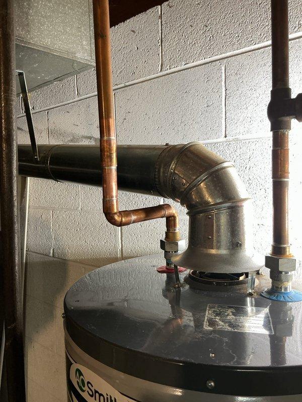 Responded to leaking hot water outlet fitting on an 8-9 year old A.O. Smith tanked water heater located in basement. Upon inspection, identified failed packing in the hot side outlet coupling causing active leak. Replaced defective outlet fitting coupling with new components, ensuring proper seal and connection integrity. Tested system operation and verified no leaks present at repair site or surrounding connections. Unit restored to full working condition.