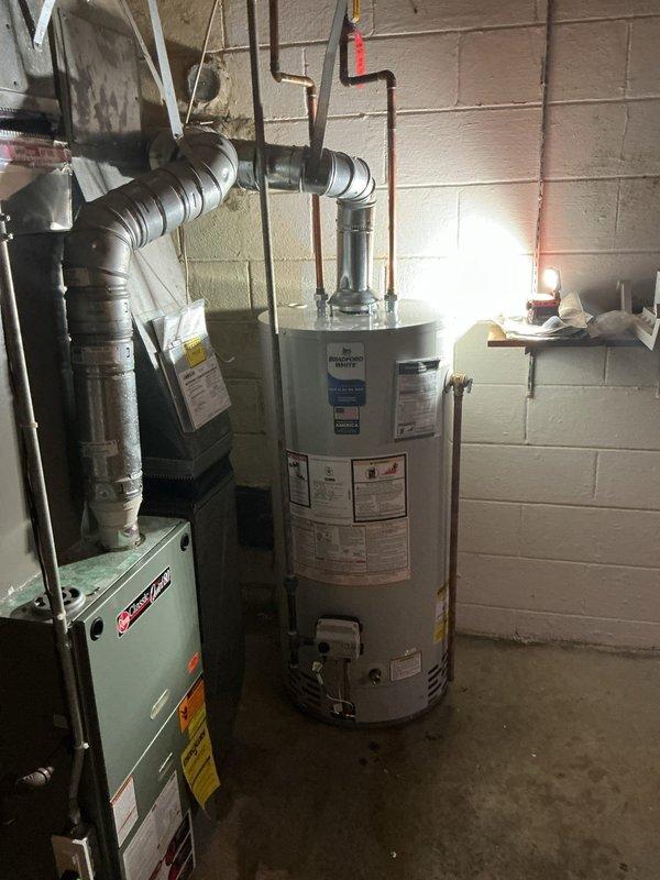 Responded to no hot water complaint and confirmed water heater failure in basement. Removed existing failed unit and installed new 40-gallon short tank-style water heater. Reconnected copper supply lines, drain valve, and temperature/pressure relief valve with discharge piping. Verified all connections for proper operation and tested unit functionality before completion.