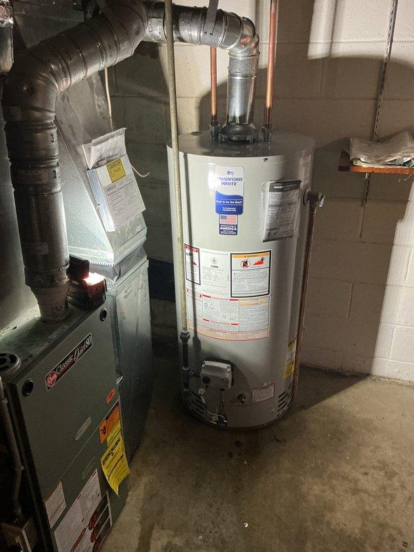 Responded to no hot water complaint and confirmed water heater failure in basement. Removed existing failed unit and installed new 40-gallon short tank-style water heater. Reconnected copper supply lines, drain valve, and temperature/pressure relief valve with discharge piping. Verified all connections for proper operation and tested unit functionality before completion.