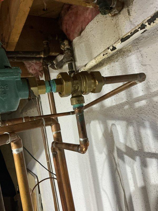 Completed backflow preventer replacement on residential plumbing system. Removed failed brass backflow assembly and installed new unit with proper threaded connections and sealing. Verified all copper pipe connections, tested system operation, and confirmed no leaks at valve body or surrounding joints.