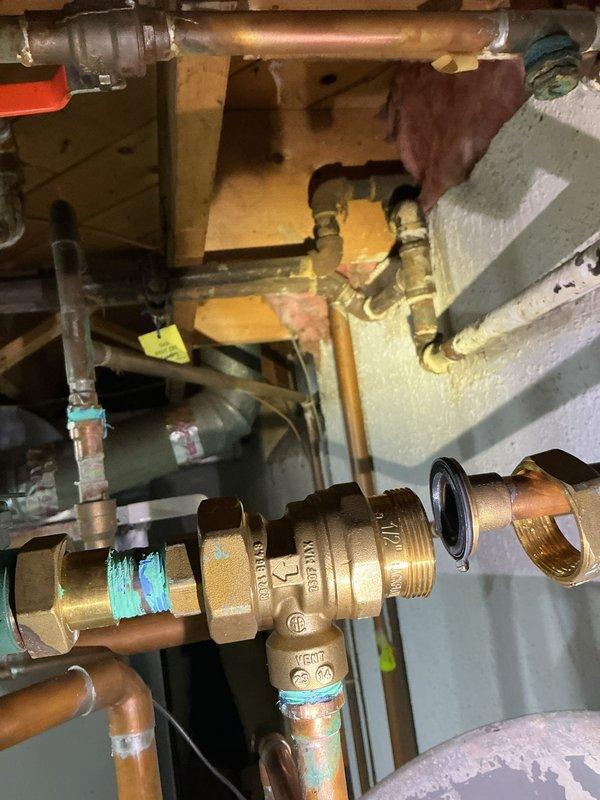 Completed backflow preventer replacement on residential plumbing system. Removed failed brass backflow assembly and installed new unit with proper threaded connections and sealing. Verified all copper pipe connections, tested system operation, and confirmed no leaks at valve body or surrounding joints.
