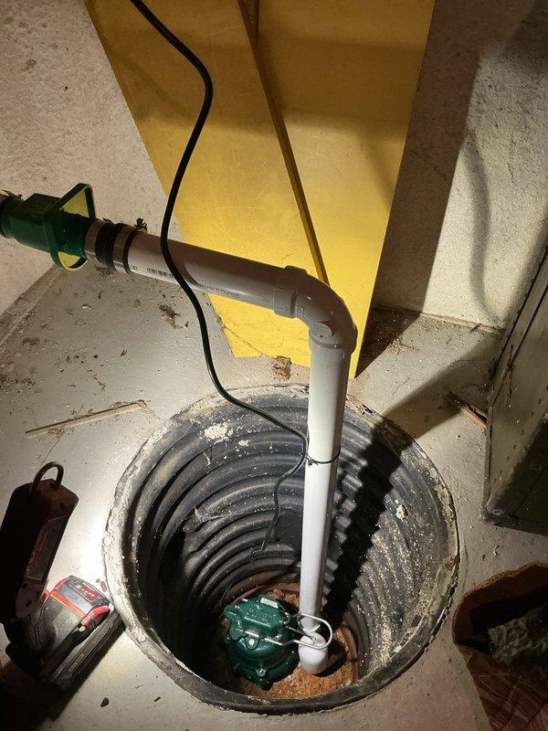 Completed sump pump replacement in basement utility area, installing new pump unit with PVC discharge piping in existing pit liner. Addressed drainage concerns and installed dehumidifier system to manage basement moisture levels. Identified water heater venting deficiency requiring extension from current 10-inch length to code-compliant 12-inch minimum. Scheduled follow-up visit to correct water heater vent installation by removing temporary tape connection and installing proper zip screws, as well as to service dryer vent system.