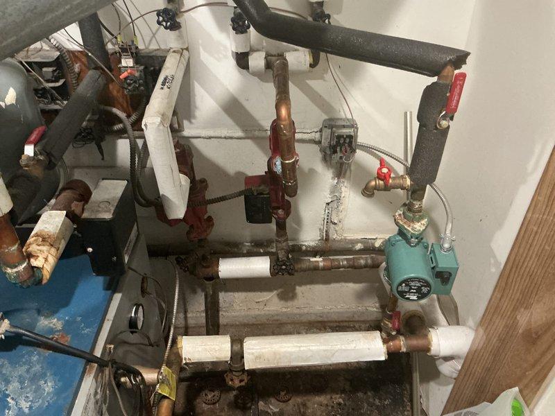 Responded to service call for 12-year-old steam boiler system with reported circulating pump failure and damaged radiator requiring replacement. Upon arrival, conducted comprehensive inspection of boiler unit located in closet, evaluating all mechanical components, piping connections, and circulation system. Assessed condition of existing circulator pump and verified operational status of heating distribution system. Performed thorough examination of radiator network to identify failed unit and determine extent of damage. Inspected all pipe connections, valves, and fittings throughout the system, noting areas of corrosion on copper piping and aging mechanical components. Evaluated boiler controls, expansion tank mounting, and associated plumbing infrastructure to ensure system integrity. Documented current system conditions including visible oxidation on metal components and wear patterns consistent with equipment age. Provided technical assessment and recommendations for circulator pu