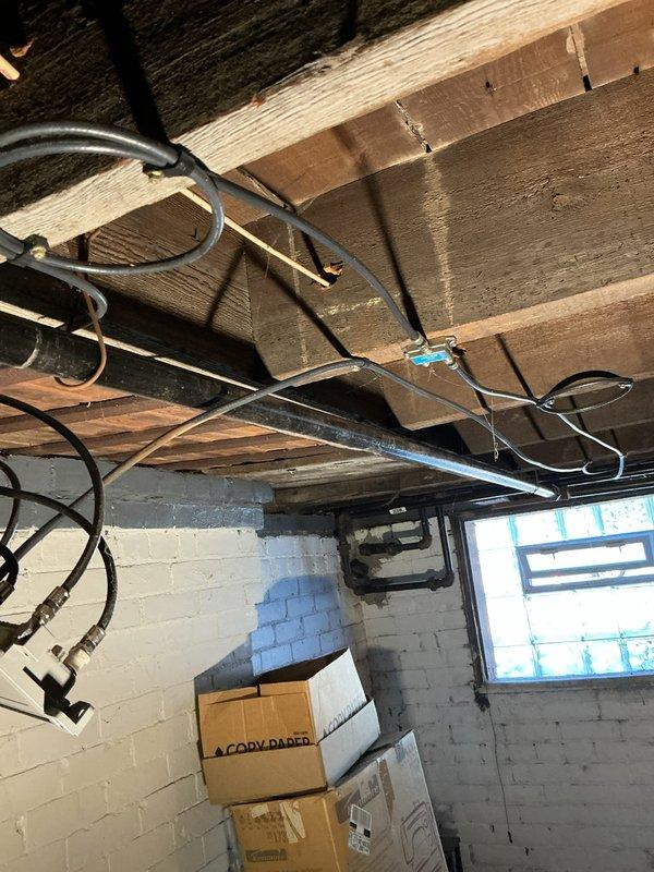 Completed gas line repairs in commercial basement utility area. Addressed aging copper pipe infrastructure showing oxidation and installed new black gas line routing along exposed floor joists with proper securing methods and code-compliant fittings. Ensured all connections were properly supported and secured to structural elements for safety and longevity of the installation.