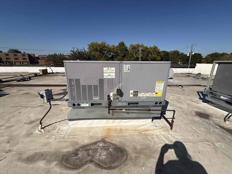 Performed scheduled commercial HVAC maintenance agreement service on two rooftop package units. Accessed RTUs using ladder to complete inspection and filter service. Inspected both rooftop units for proper operation, checked electrical connections and conduit integrity, and verified mounting brackets were secure. Replaced air filters in return air compartment with new pleated filters to maintain proper airflow and system efficiency. Noted existing roof membrane staining around unit base. Both RTU systems operational upon completion of maintenance visit.