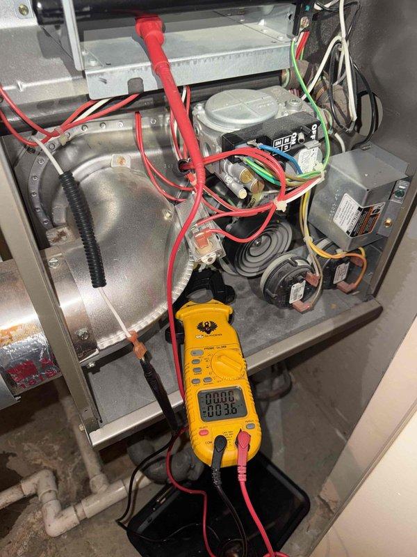 Completed comprehensive fall tune-up and safety inspection on 15-year-old Bryant 315AAV036070AFJA 80% efficiency furnace located in closet. Performed full system diagnostics including electrical testing with multimeter to verify proper voltage and amperage readings across blower motor, capacitor, and control board circuits. Inspected all electrical connections, wiring, and safety controls for proper operation. Evaluated blower assembly, heat exchanger, burner operation, and flame sensor. Checked condensate drainage system and PVC piping for proper function. Replaced air filter with requested green filter as per equipment record notes. Verified gas pressure, ignition sequence, and limit switch operation. All components operating within manufacturer specifications with no safety concerns identified. System ready for heating season.