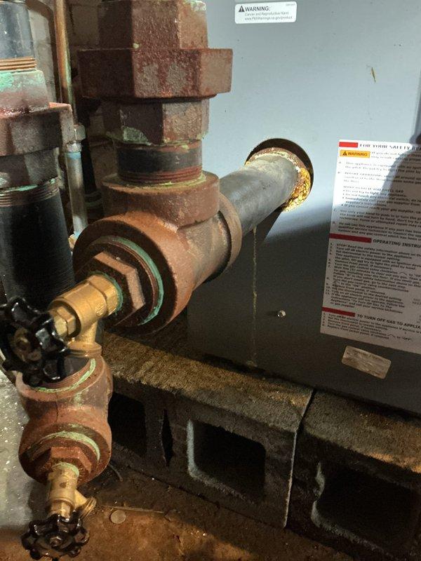 Completed comprehensive Gold Boiler Inspection and tune-up on a 5-year-old Utica PEG 187 EID steam boiler system located in basement. Identified corroded 2-inch nipple on return side requiring replacement; documented condition with photos showing significant rust and corrosion on valve assembly and piping connections. System currently operating properly with all safety controls functional.