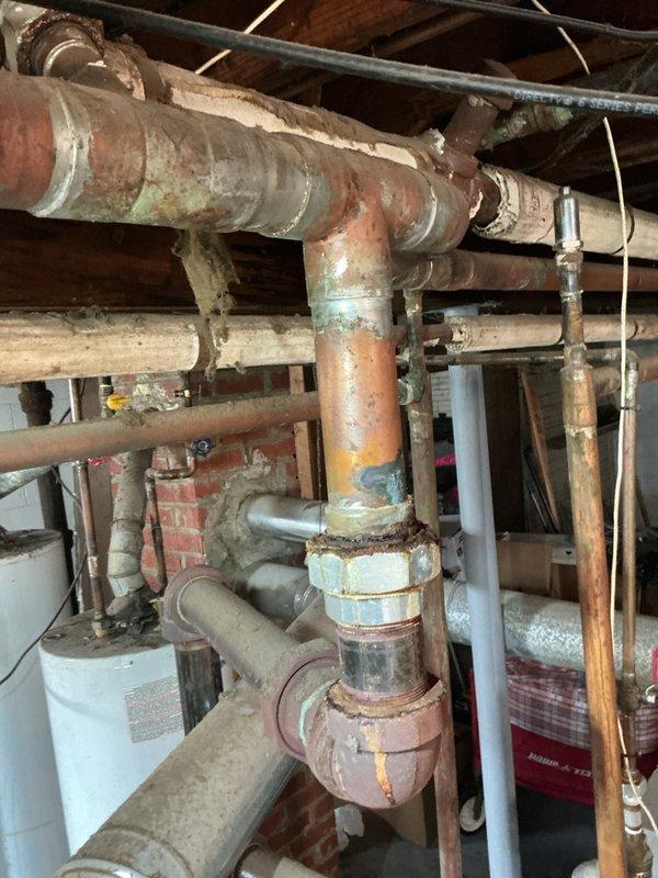 Completed comprehensive Gold Boiler Inspection on an 8-year-old steam boiler system located in basement. Performed thorough visual assessment of all accessible components including piping infrastructure, connections, and mechanical systems. Inspection revealed extensive corrosion present on copper and galvanized piping throughout the distribution system, with significant oxidation, rust buildup, and green discoloration at multiple pipe joints and fittings. Documented heavily corroded pipe connections with flaking surfaces and deteriorated insulation on aged piping sections. Evaluated system valving including gate valves and shutoff controls. Equipment currently operational at time of inspection. Captured photographic documentation of corroded piping conditions and mechanical components for maintenance records and future reference.