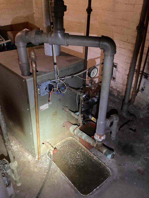 Responded to no-heat call for 10+ year old steam boiler located in basement. Upon inspection, detected elevated carbon monoxide levels indicating incomplete combustion and potential safety hazard. Performed comprehensive system evaluation including heat exchanger inspection, burner assembly assessment, and venting system analysis. Documented equipment condition with photographic evidence showing boiler installation, associated piping, electrical panel configuration, and basement utility space layout. Provided detailed estimate for necessary repairs and replacement options to address high CO levels and restore safe, reliable operation of heating system.
