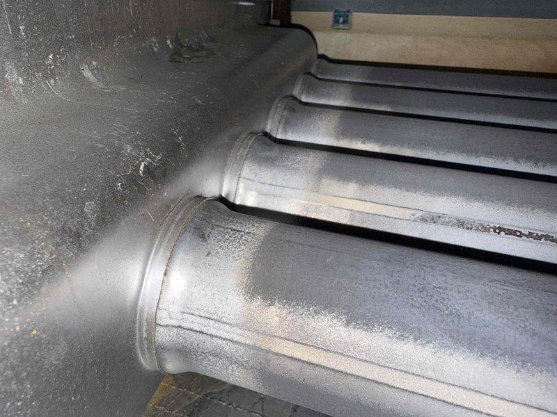 Completed fall maintenance on commercial rooftop unit. During inspection, discovered significant frost buildup on refrigerant lines and ductwork indicating possible insulation failure or refrigerant issue requiring further evaluation. Heat exchanger inspection revealed active blue flames with proper combustion, however extensive rust and corrosion present throughout cabinet interior and on heat exchanger surfaces, suggesting prolonged moisture exposure and potential unit degradation that may compromise system longevity and efficiency.