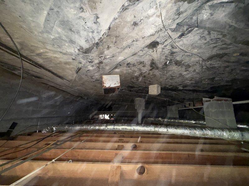 # Attic Insulation and Encapsulation Turnover Inspection

Completed turnover inspection for attic insulation upgrade to R30 value and encapsulation work. Documented existing conditions in attic space, including exposed wooden structural joists, HVAC ductwork routing, and electrical wiring installations. Photographed underside of roof decking showing previous moisture staining and discoloration patterns throughout the space. Verified flexible metallic ductwork properly installed and supported between structural members. Confirmed attic space prepared and ready for insulation installation to achieve R30 thermal resistance rating and encapsulation barrier application. All structural framing, mechanical systems, and electrical components documented prior to insulation work proceeding.