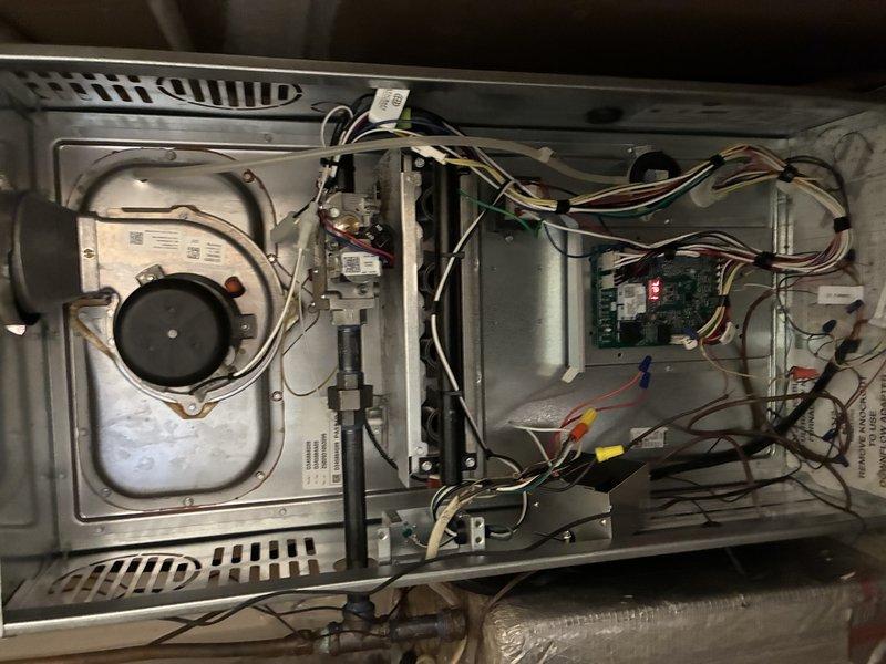 Completed first Protection Plan Preventive maintenance visit on residential HVAC system consisting of one heating unit and one air handler with UV light system under 12-month warranty. Performed comprehensive inspection of furnace and air handler assembly located in utility closet. Removed access panels and inspected all internal components including blower motor assembly, gas valve connections, ignition system, and control board. Verified proper operation of circuit board with LED indicator functioning correctly. Inspected all wire harnesses and electrical connections throughout unit for secure termination and proper routing. Examined ductwork connections including curved metallic elbow and insulated supply ducts with reflective foil backing. Confirmed all ventilation pathways clear and unobstructed. Verified UV light system present and installed in accordance with manufacturer specifications. Checked all safety labels and warning placards properly affixed to equipment. Photographed e