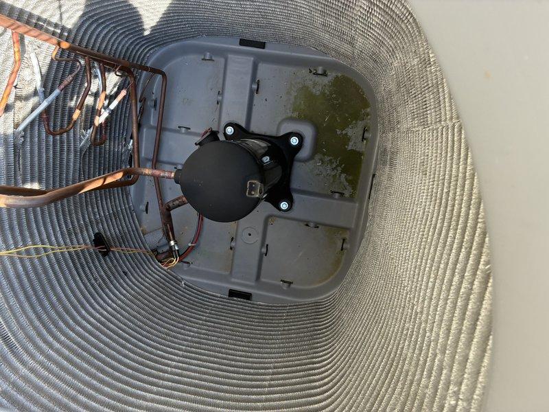 Completed Service Agreement Visit inspection of residential HVAC system. Documented basement furnace installation including gray metal furnace unit with proper ventilation, metallic ductwork with reflective insulation, and copper refrigerant line connections. Photographed outdoor condensing unit from above, noting black circular fan motor assembly and gray drain pan with standing water and visible algae growth indicating drainage concerns that may require attention during future maintenance visits.