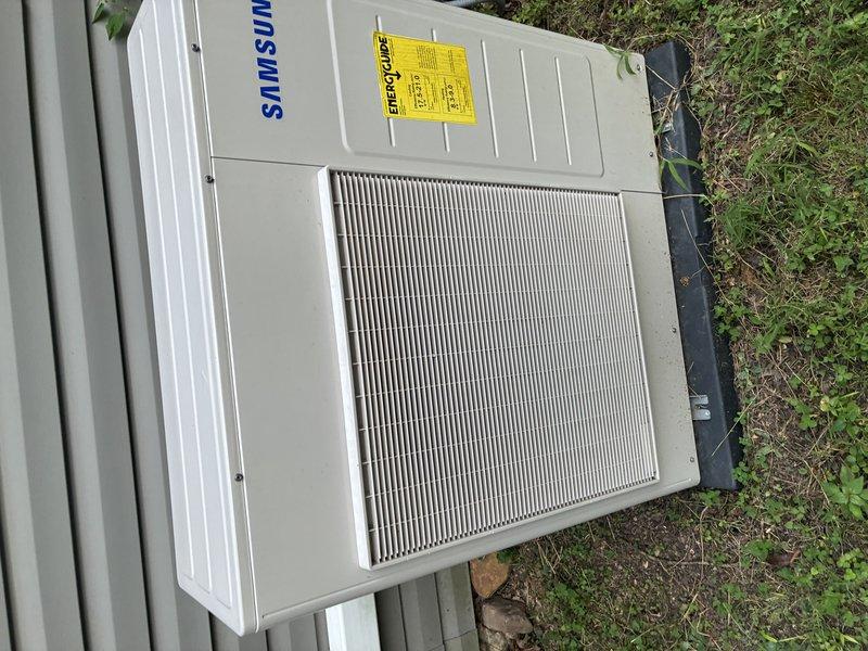 Responded to warranty callback for water leak with no trip charge. Upon arrival, inspected Samsung outdoor HVAC unit and surrounding area. Examined condensate drain system including PVC discharge piping and pad area where previous water leak was reported. Verified unit operation and monitored for water discharge. Inspected drain line routing, connections, and termination point near foundation. Checked for proper drainage flow and confirmed no active leaking observed during service call. Documented unit condition and drain system with photographs for warranty records.