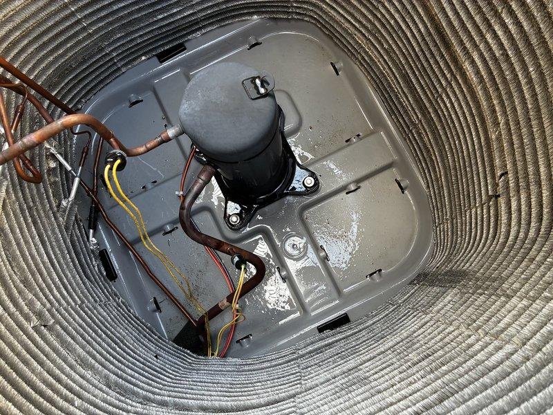 Completed Protection Visit (PPP) on residential air conditioning condenser unit. Performed comprehensive visual inspection of outdoor unit, including examination of top grille ventilation, exterior panels, and electrical connections. Documented condition of compressor assembly, refrigerant lines, and associated copper piping. Noted moisture accumulation on base plate and verified mounting hardware integrity. Unit operational with normal wear patterns observed on metallic surfaces and copper tubing.