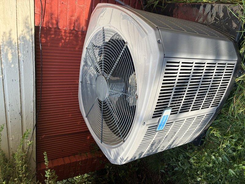 Completed comprehensive Clean & Check service on both heating and cooling systems per customer request. Technician wore mask throughout service as requested. Performed thorough inspection and maintenance of outdoor condenser unit, which was found surrounded by overgrown vegetation and vines that had begun climbing the equipment. Cleared vegetation from around unit base and sides to ensure proper airflow and prevent potential damage to components. Cleaned condenser coils and verified fan operation on outdoor unit positioned against building exterior. Inspected all accessible system components, checked refrigerant levels, tested electrical connections, and verified proper system operation for both heating and cooling modes. Unit returned to normal operating condition with improved airflow following vegetation removal and standard maintenance procedures.