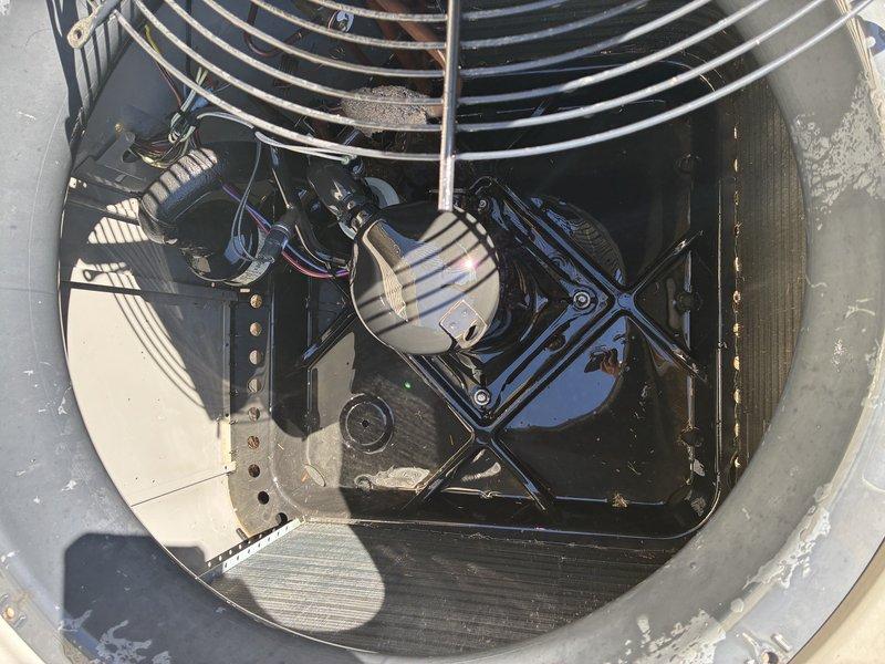 Completed routine Service Agreement Visit on residential air conditioning system. Performed visual inspection of outdoor condensing unit, documenting equipment condition through photographic records. Unit exterior shows normal operational wear with weathering consistent with outdoor exposure. Condenser positioned on concrete pad with proper clearances maintained from structure. Refrigerant lines and electrical connections inspected and found secure. Interior components including condenser fan motor, fan guard, and mounting hardware examined. Noted typical moisture staining and debris accumulation within unit housing consistent with normal outdoor operation. All major components operational with standard service wear patterns observed.