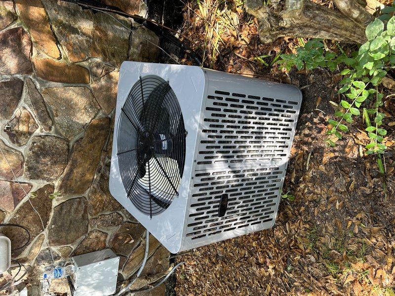 Completed routine service agreement maintenance visit on outdoor heat pump system. Performed comprehensive inspection of condenser unit exterior and internal components. Verified proper operation of compressor, examined refrigerant lines for leaks or damage, and inspected electrical connections including wiring and terminal points. Checked fan motor operation and blade condition through protective grille. Assessed unit mounting stability and clearance from surrounding vegetation and building foundation. Documented equipment condition through photographic record showing exterior housing with perforated ventilation grilles and internal view of compressor assembly, copper refrigerant piping, and electrical wiring harness. Noted debris accumulation around base of unit from seasonal leaf fall. System operating within normal parameters under existing warranty coverage without ultraviolet light component.