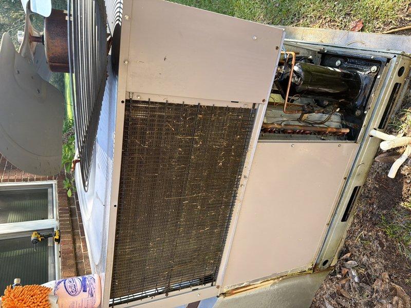 Completed comprehensive clean and check service on residential HVAC system including outdoor condensing unit and associated components. Inspected and cleaned condenser coils which showed significant dirt accumulation and outdoor debris. Removed panels to access internal components including compressor assembly, copper refrigerant lines, and mechanical framework. Verified proper operation of all accessible system components. Inspected water heater tank and surrounding plumbing connections. System is operating within normal parameters under active warranty coverage. Documented equipment condition with photos for service records.