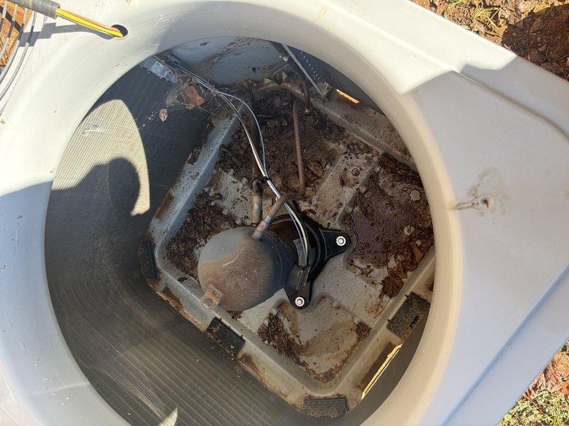 Performed a clean and check on two outdoor condenser units. Removed the fan assemblies and guards to access the interiors, then cleared accumulated leaves, dirt, and debris from the base pan of the primary unit and inspected the condenser coil, compressor, refrigerant lines, and electrical wiring. Noted rust and corrosion along the base pan edges and mounting points, and recommended monitoring these areas for further deterioration.