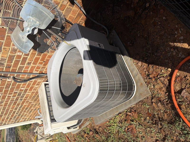 Performed a clean and check on two outdoor condenser units. Removed the fan assemblies and guards to access the interiors, then cleared accumulated leaves, dirt, and debris from the base pan of the primary unit and inspected the condenser coil, compressor, refrigerant lines, and electrical wiring. Noted rust and corrosion along the base pan edges and mounting points, and recommended monitoring these areas for further deterioration.