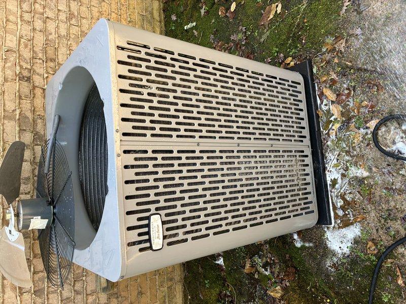 Performed a preventive maintenance inspection on the heat pump outdoor unit. Removed the top fan guard to access the interior, then cleaned and rinsed the condenser coil to remove accumulated dirt, debris, and grime. Cleared surrounding vegetation and debris from the unit base, checked the compressor, refrigerant lines, and wiring, and reinstalled the fan assembly and guard once cleaning was complete.