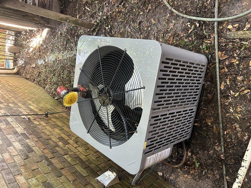 Performed a Service Agreement Visit on the heat pump system, including cleaning of the outdoor condenser unit. Removed accumulated debris from the condenser coil and fan guard using a brush attachment, then thoroughly flushed the coil with water to restore proper airflow and heat transfer. Inspected the compressor, refrigerant lines, and electrical components in the condenser cabinet, and noted standing water in the base pan following the rinse. Confirmed the system has a UV light installed.
