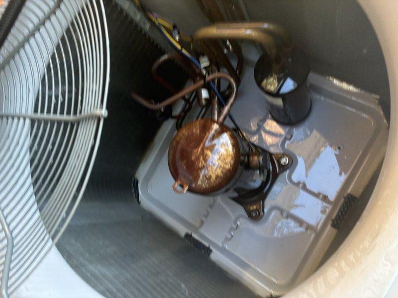 Performed the second service agreement visit on the heat pump system, inspecting the outdoor condenser unit and documenting its condition. Found heavy rust and corrosion on the compressor shell, standing moisture in the base pan, and an accumulation of leaves, twigs, and debris around the compressor and coil. Recommend further evaluation of the compressor and drainage condition, as the corrosion may indicate ongoing moisture exposure.
