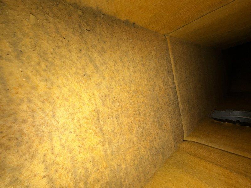 Performed a turnover inspection of the attic-mounted air handler and heating system, with the access panel removed to evaluate the control board, wiring, terminal connections, and supply plenum and flex duct connections. Inspection revealed a failed heat exchanger, and interior duct inspection showed fiberglass duct liner with dirt and possible microbial staining, along with disturbed attic insulation around the equipment. Documented findings with photos and recommended replacement of the heat exchanger and further evaluation of the duct liner condition.