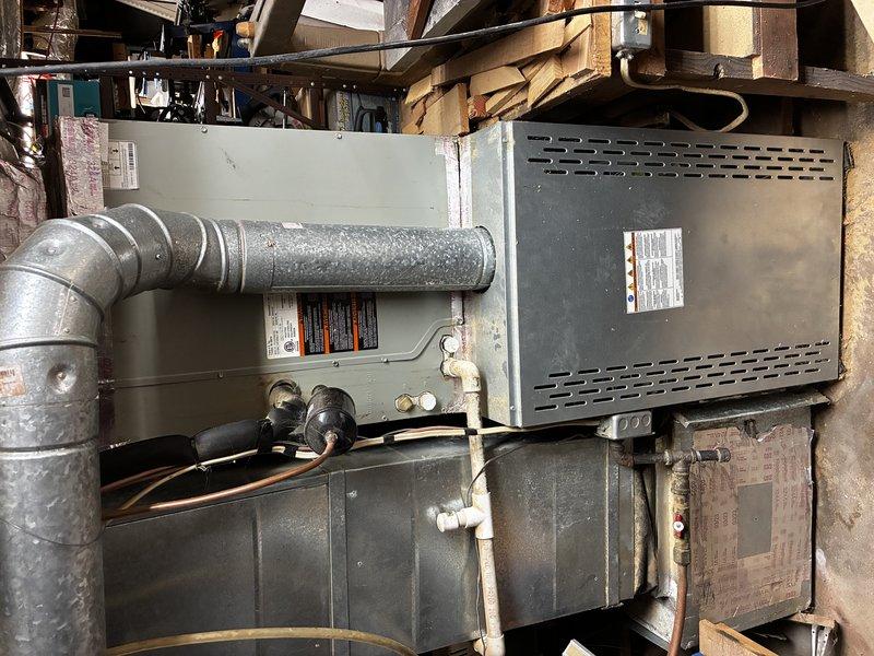 Performed a scheduled service agreement visit on a horizontal gas-fired furnace and air handler assembly installed in a confined attic space. Inspected the cabinet, flue pipe and elbow connections, gas line assembly and shutoff valve, low-voltage and line-voltage wiring, refrigerant line insulation, and PVC condensate drain line, and documented unit labeling and overall system condition. Noted dust accumulation, surface corrosion on the plenum and lower ductwork, and aged, torn foil-faced insulation at the plenum, which should be monitored and addressed to maintain airflow efficiency and system longevity.