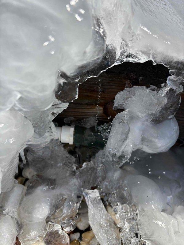 Responded to no-heat service call for geothermal unit displaying E2 error code. Discovered severe ice formation on system components and identified frozen condensate line beneath customer's deck. Thawed ice blockage and restored proper system operation.