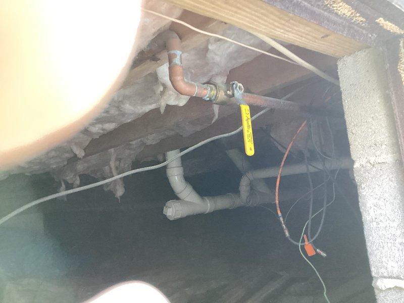 Responded to winterization request for outdoor water shut-off. Located and accessed main water valve with yellow lever in crawlspace area with exposed insulation and PVC drainage system. Successfully shut off water supply to prevent freezing damage to exterior plumbing fixtures. Verified operation of shut-off valve and confirmed completion with property owner.