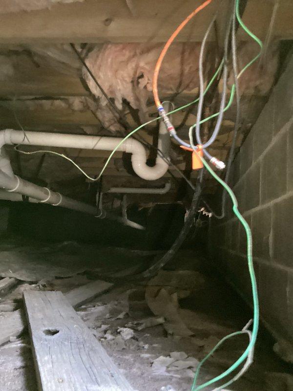 Responded to winterization request for outdoor water shut-off. Located and accessed main water valve with yellow lever in crawlspace area with exposed insulation and PVC drainage system. Successfully shut off water supply to prevent freezing damage to exterior plumbing fixtures. Verified operation of shut-off valve and confirmed completion with property owner.