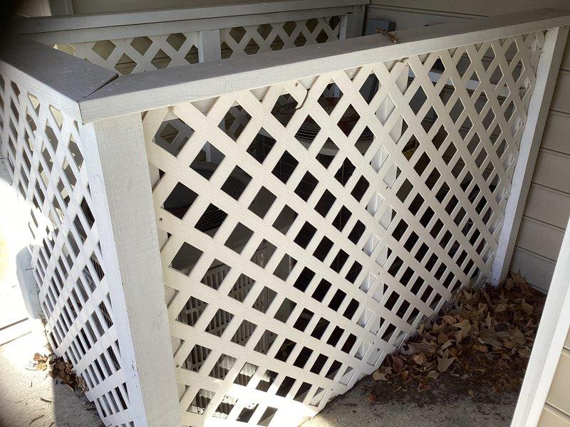 Conducted an estimate for replacement of an HVAC system serving the first and second floors with air handler located in garage. Inspected existing outdoor units housed within white lattice enclosure, noting aged condensers with visible wear and dirt accumulation on exterior fins.