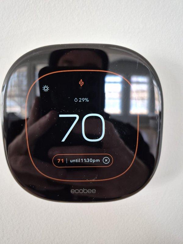 Performed scheduled tune-up service on HVAC system. Conducted electrical diagnostics using clamp meter on circuit panel, verifying proper voltage readings and connections. Inspected ecobee smart thermostat functioning at 70°F with 29% battery remaining, confirming proper operation and temperature settings.