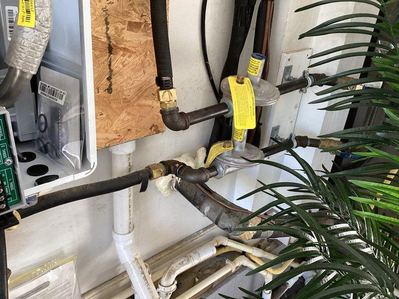 Performed scheduled maintenance on two tankless water heaters. Inspected backflow prevention assembly, verifying all components were functioning correctly with no leaks present. Checked valve assemblies (marked with yellow tags) and confirmed proper operation of the PVC drainage system. All connections and fittings were examined and found to be in good working condition.