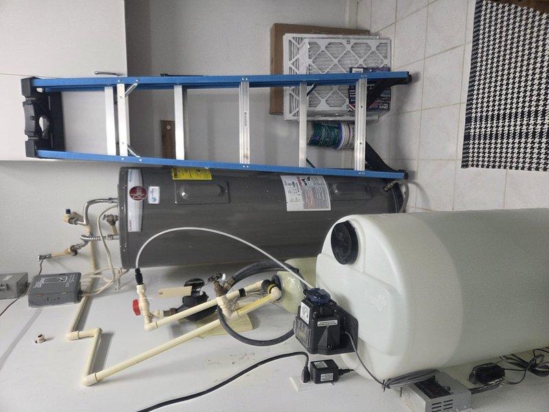 Performed scheduled heating maintenance service on dual-system setup. Inspected water heater showing significant corrosion and mineral buildup along the gasket seam. Examined mechanical room equipment including water treatment system with connected PVC piping, pump controller, and return air filtration. Customer's maintenance agreement requires renewal.