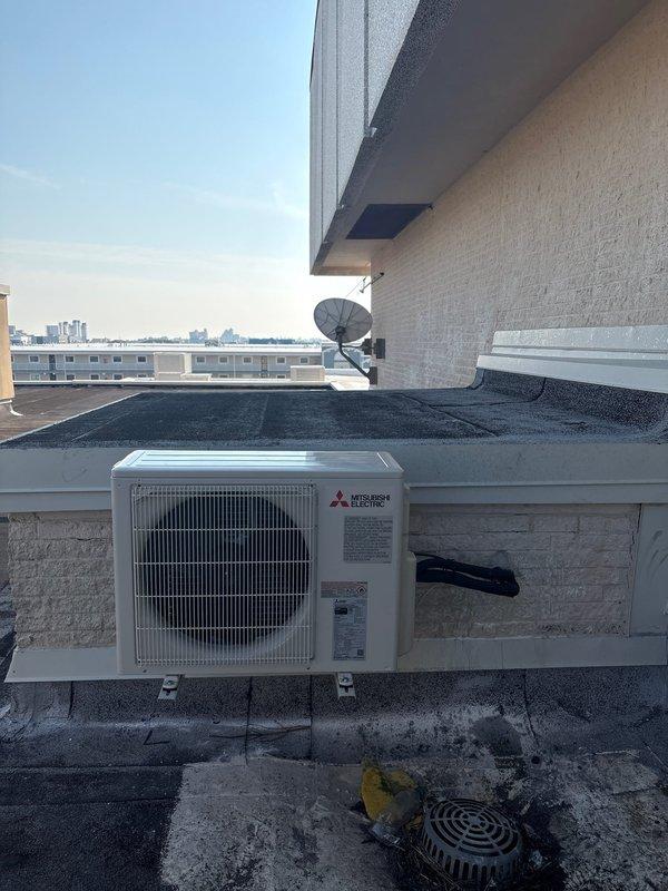 Successfully completed installation of a Mitsubishi Electric mini-split system with PUZ-AK12NL heat pump and PKA-AL12NL fan coil unit. Mounted outdoor unit on wall bracket on elevator shaft roof and installed indoor fan coil above machine room door, with refrigerant lines concealed in metal top hat and properly fire caulked. System includes PAR-FL32MA wireless remote control, Gobi II condensation pump, and surge disconnect, with all connections tested and verified operational.