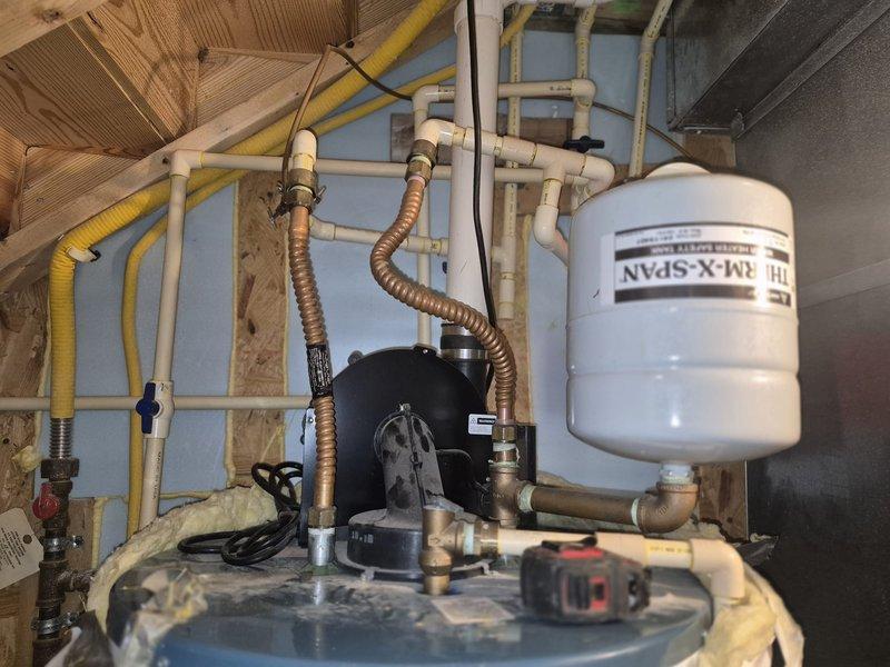 Performed inspection of existing water heater system with insulated tank and associated plumbing components. Assessed current installation which includes expansion tank, PVC and copper piping, shutoff valves, and circulation pump. Provided customer with replacement options for standard tank water heater as well as tankless alternatives per their request.