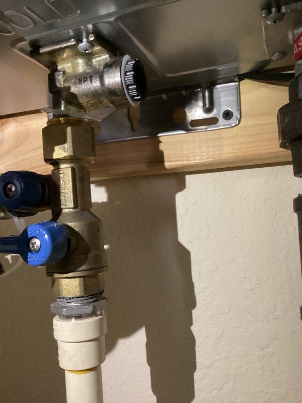 Performed scheduled maintenance on tankless water heater system. Inspected brass valves, fittings, and PVC drainage components, confirming all were in proper working condition. Removed and cleaned filter as indicated by "Pull To Clean" access tab, and checked motor connections to ensure proper electrical functionality.