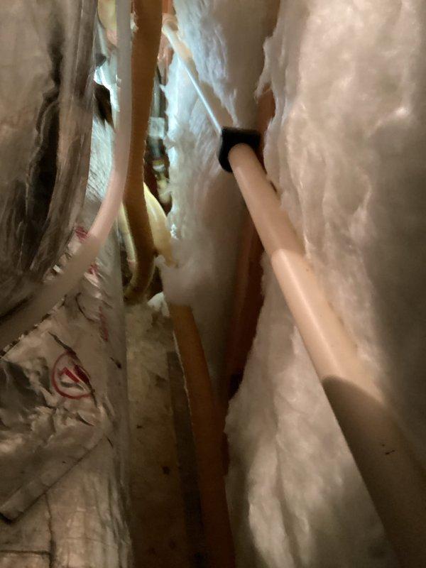 Performed inspection of tankless water heater system in confined utility space. Examined copper piping, PVC connections, and flexible metal hose components. Customer advised about renewal contract options for tankless unit maintenance.