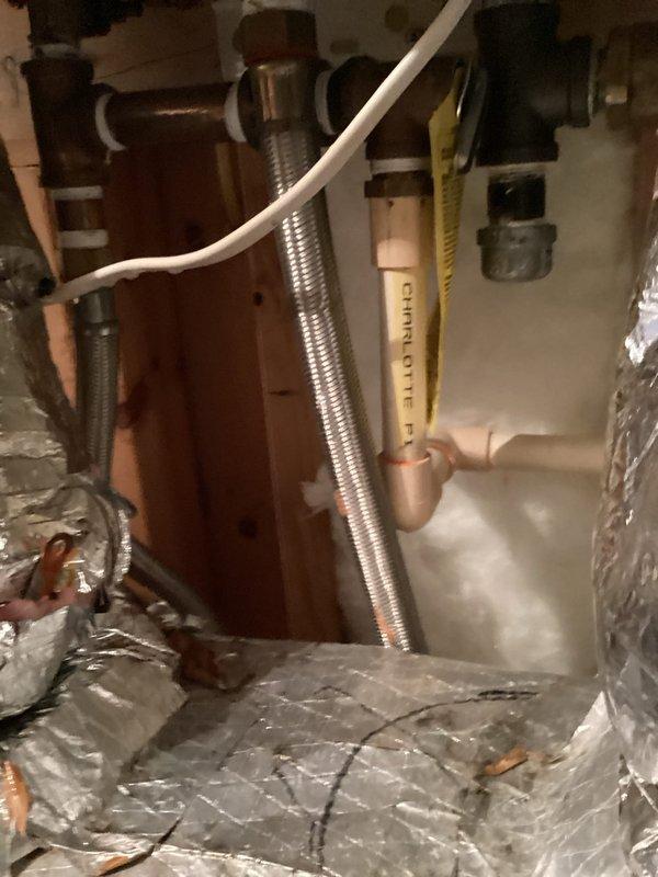 Performed inspection of tankless water heater system in confined utility space. Examined copper piping, PVC connections, and flexible metal hose components. Customer advised about renewal contract options for tankless unit maintenance.