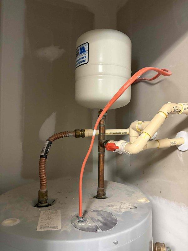Performed routine maintenance on water heating system in utility closet (19.5" width). Inspected expansion tank, copper piping connections, and PVC network. Verified proper operation of system components and confirmed adequate clearance for service access.