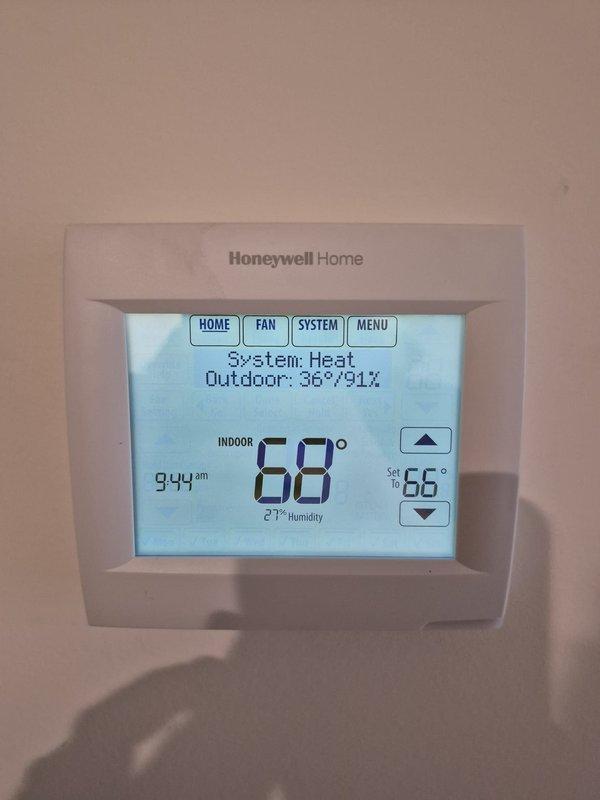 Performed routine heating system maintenance and inspection. Conducted electrical testing of HVAC components using Fieldpiece SC440 meter, confirming proper voltage readings. Verified thermostat operation with system maintaining 68° indoor temperature at 27% humidity while outdoor conditions were 36°/91%.