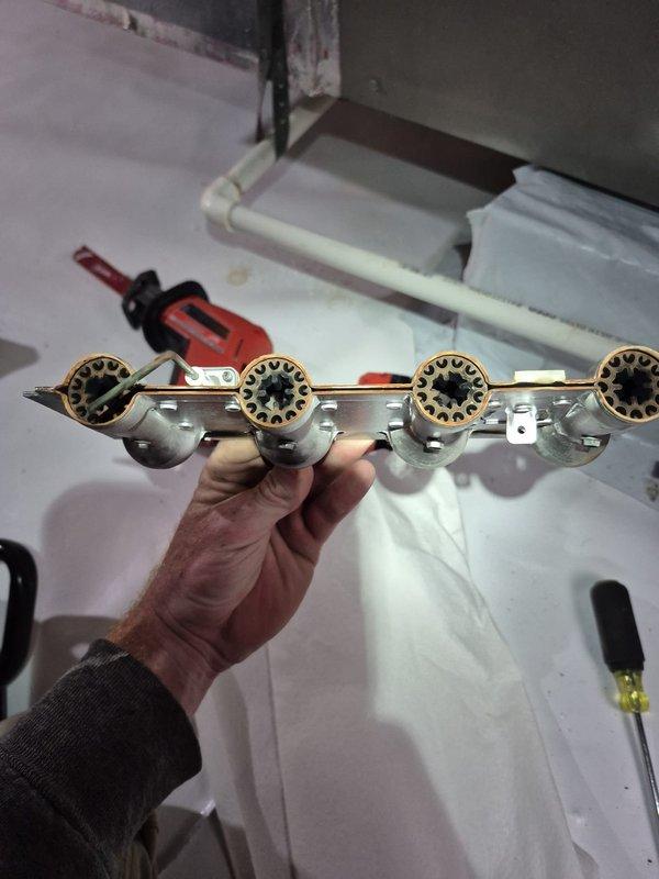 Responded to no-heat service call for unit under 10 years old. Diagnosed ignition failure at manifold assembly. Removed and cleaned flame sensor and burner orifices to restore proper ignition sequence, then verified normal operation through complete heating cycle.